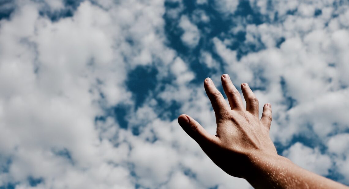 person hand reaching for the sky