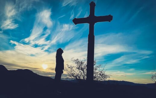 a person standing in front of a cross
