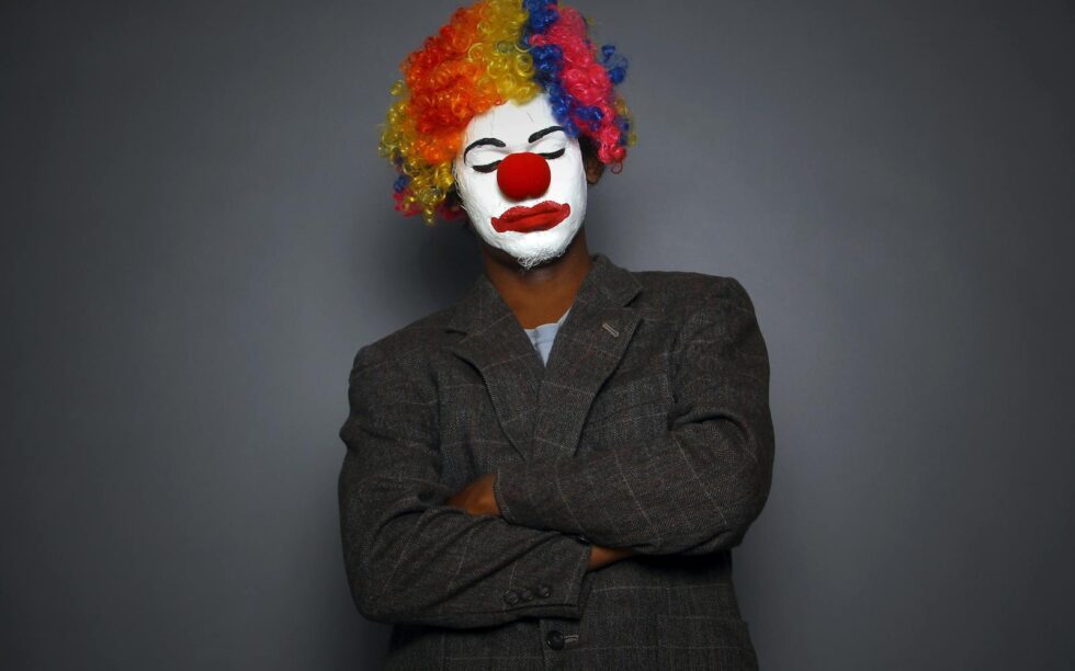 Vibrant clown portrait with face paint and colorful wig, perfect for circus or arts themes.