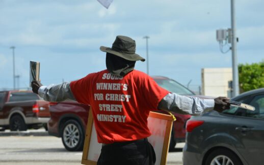 A street preacher spreading religious messages in a Florida parking lot.