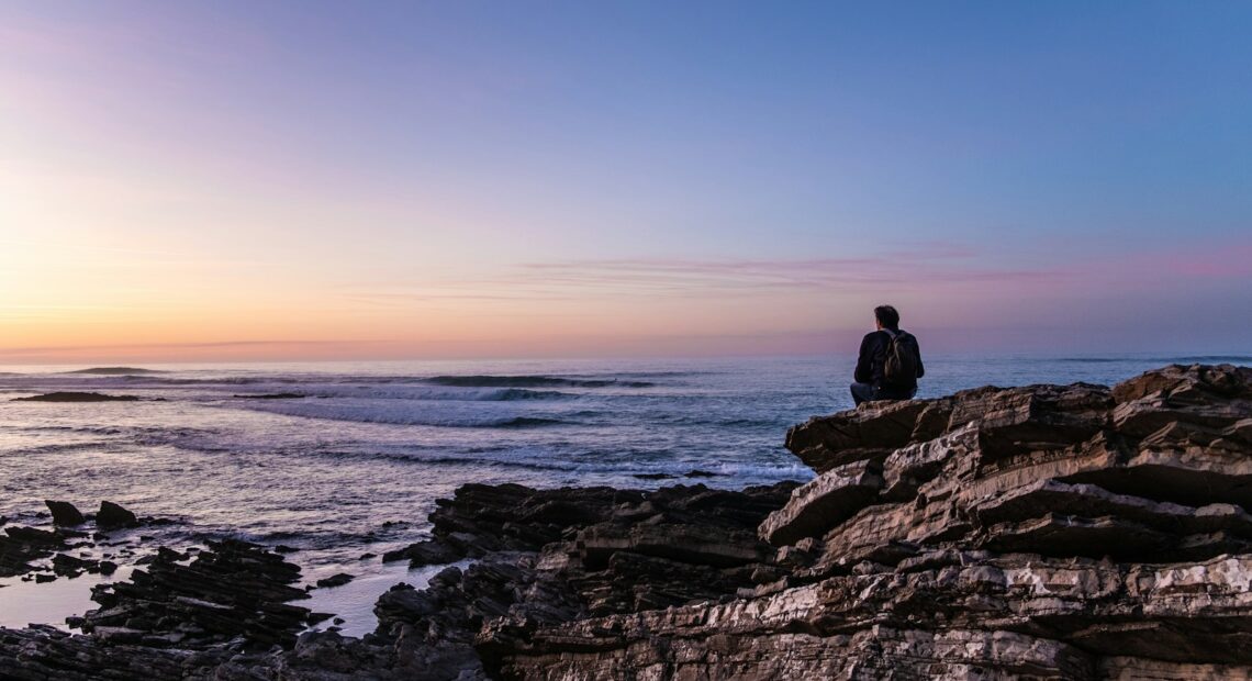 person sitting on cliff