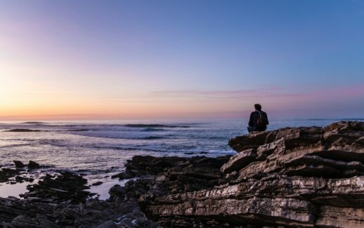 person sitting on cliff